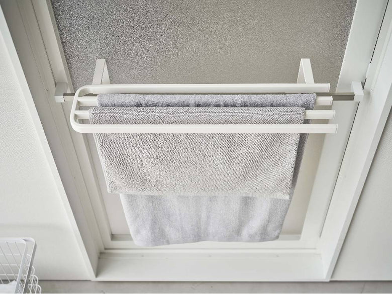 浴室扉に取り付けられた銀色のステンレス製タオルハンガーに複数のタオルが掛かっている様子