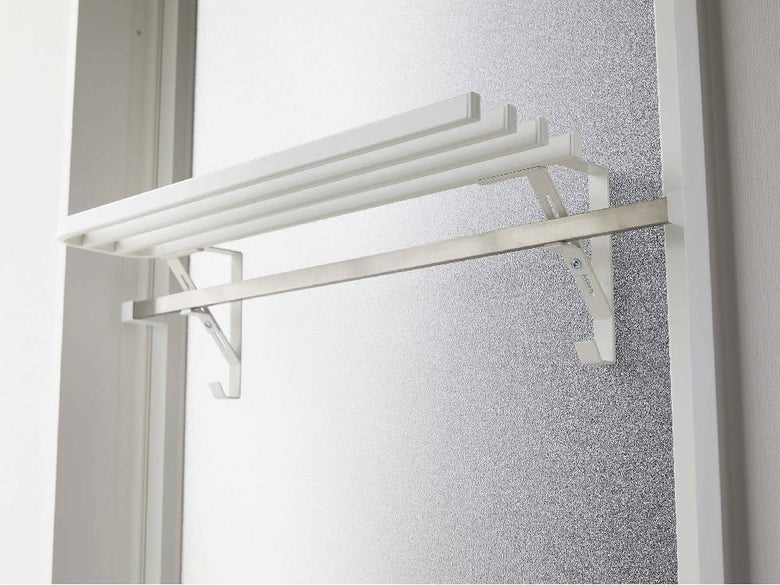 タワー型浴室扉に取り付けられたシルバーのバスタオルハンガーと棚