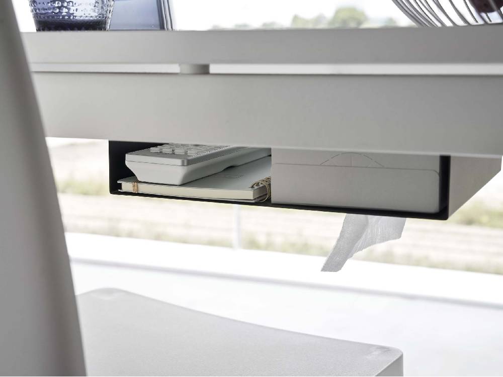 オフィスのテーブル下に設置されたシルバーのスチール製タワー型つっぱり棒収納ラック