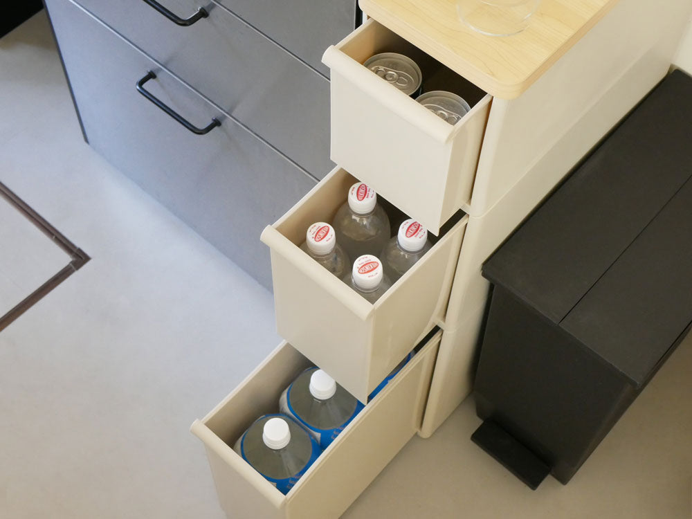 グレーのキッチン用スリムストレージキャビネット。木製天板と複数の引き出しが備わった収納家具。