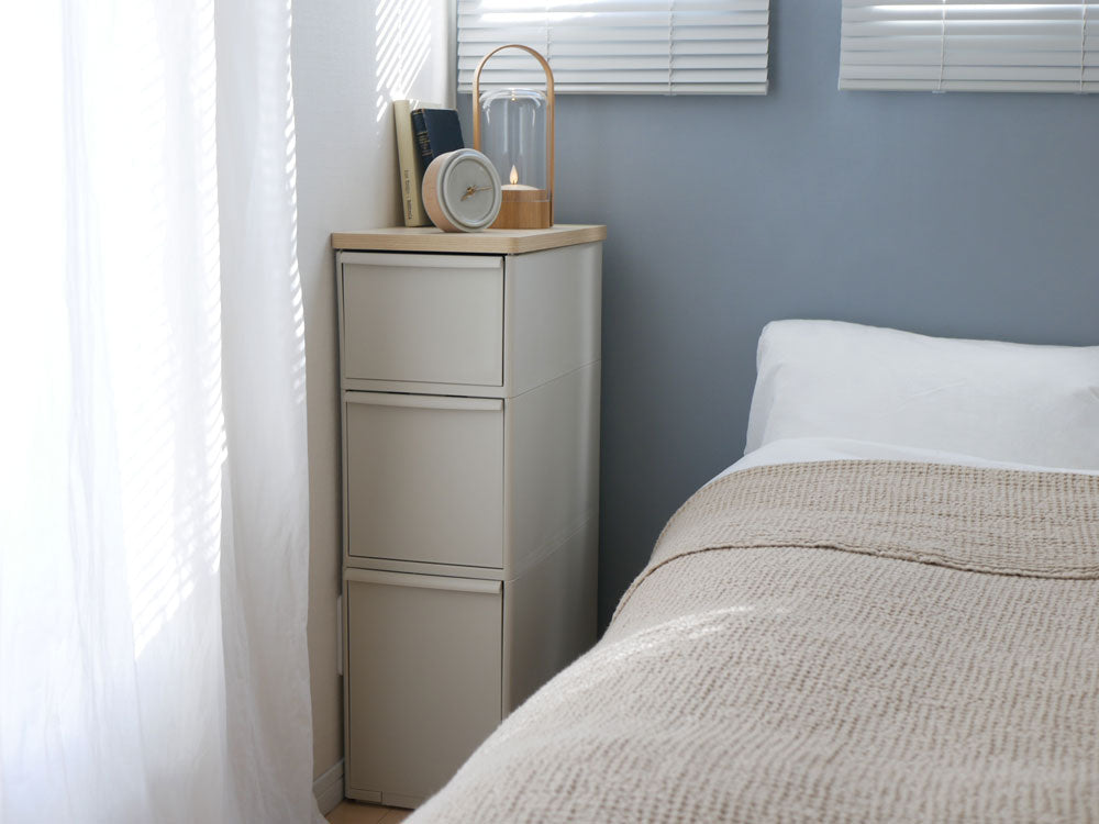 木製のグレーキャビネットが室内の木張りフロアに置かれ、複数の引き出しが整然と配置されたインテリア