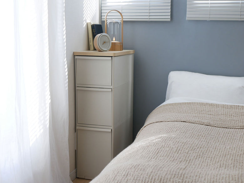 木製のグレーキャビネットが室内の木張りフロアに置かれ、複数の引き出しが整然と配置されたインテリア