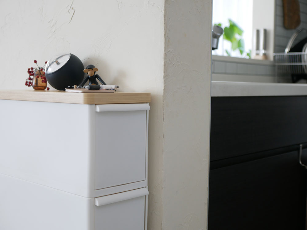 オールホワイトの耐熱木天板を備えたスリムなストッカーストッカーで、複数の引き出しが配置されたモダンな収納家具