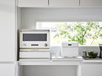 銀色のスチール製キッチン家電用下スライドテーブル。天板とスライド部分を備えた家庭用厨房家具