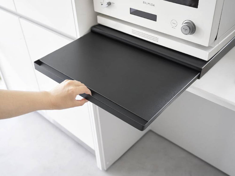 キッチンのキャビネット下に設置されたタワーキッチン家電下スライドテーブルに調理器具や家電が収納されている様子