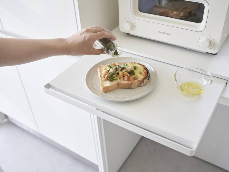 tower/タワーのキッチン家電下スライドテーブルが設置されたキッチンカウンターに、食器や小型家電が整然と並んでいる様子