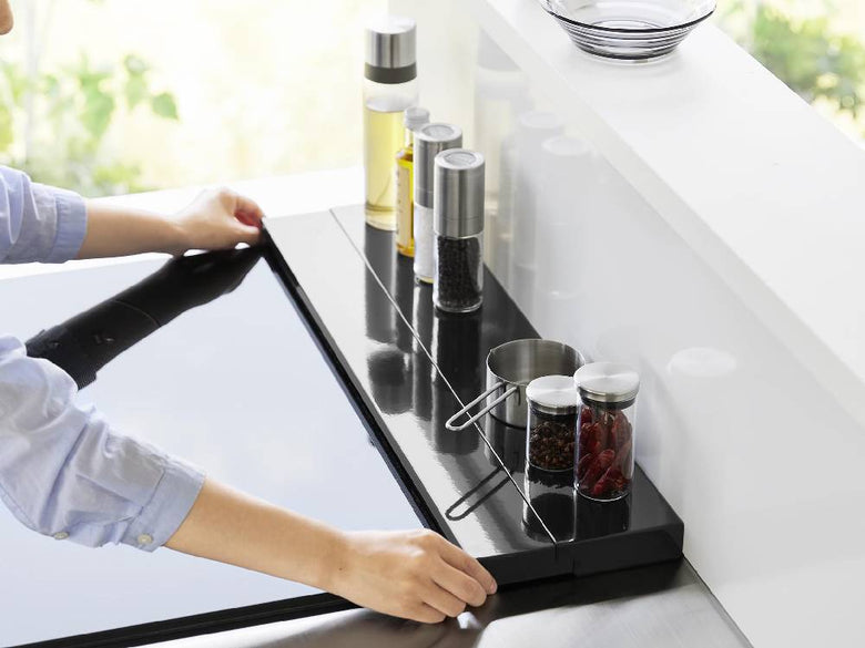 スチール製の奥行伸縮排気口カバー60cmがキッチンのカウンタートップに設置され、コンロの上に美しくフィットしている様子