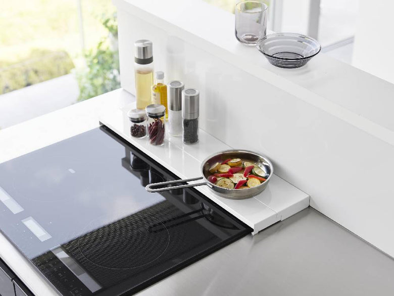 キッチンのガスコンロ上に設置されたタワー奥行伸縮排気口カバー。スチール製で約60cm幅、シリコーン滑り止め付き。