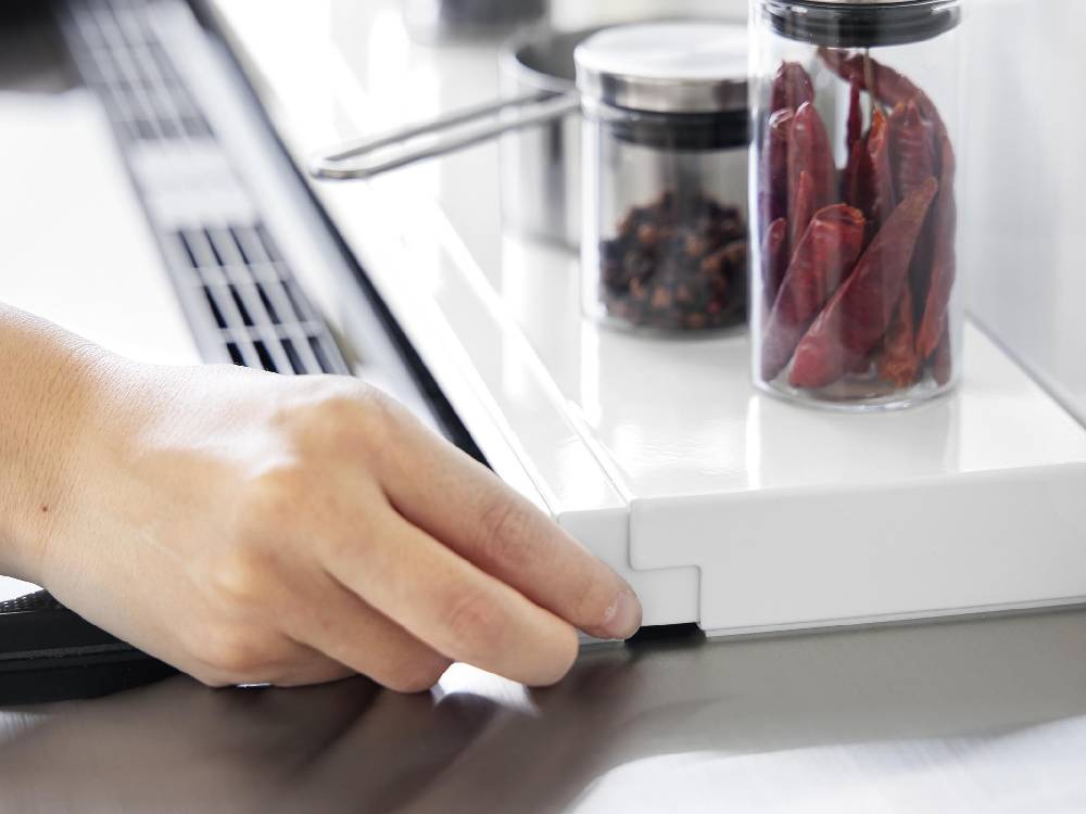 キッチンカウンタートップ上に設置されたスチール製の奥行伸縮排気口カバー