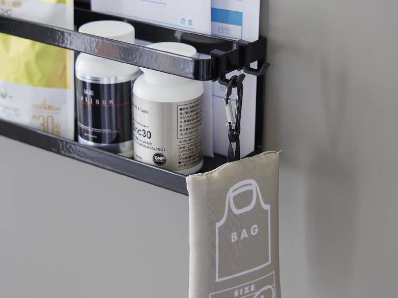 スチール製のマグネット冷蔵庫横サプリ＆調味料ラックがキッチンの棚に設置され、調味料瓶や家庭用品が整然と並べられている様子