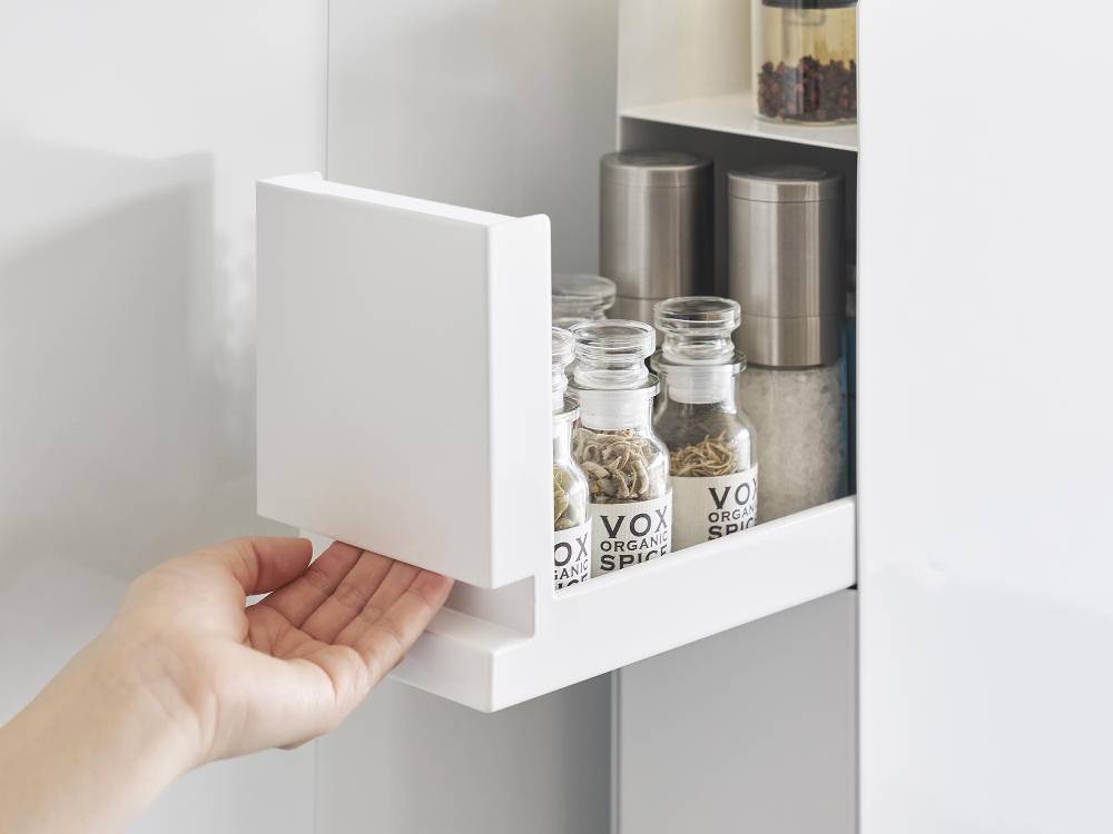 キッチン棚に設置された2段の隠せる調味料ラックに、調味料ボトルが整然と並べられています