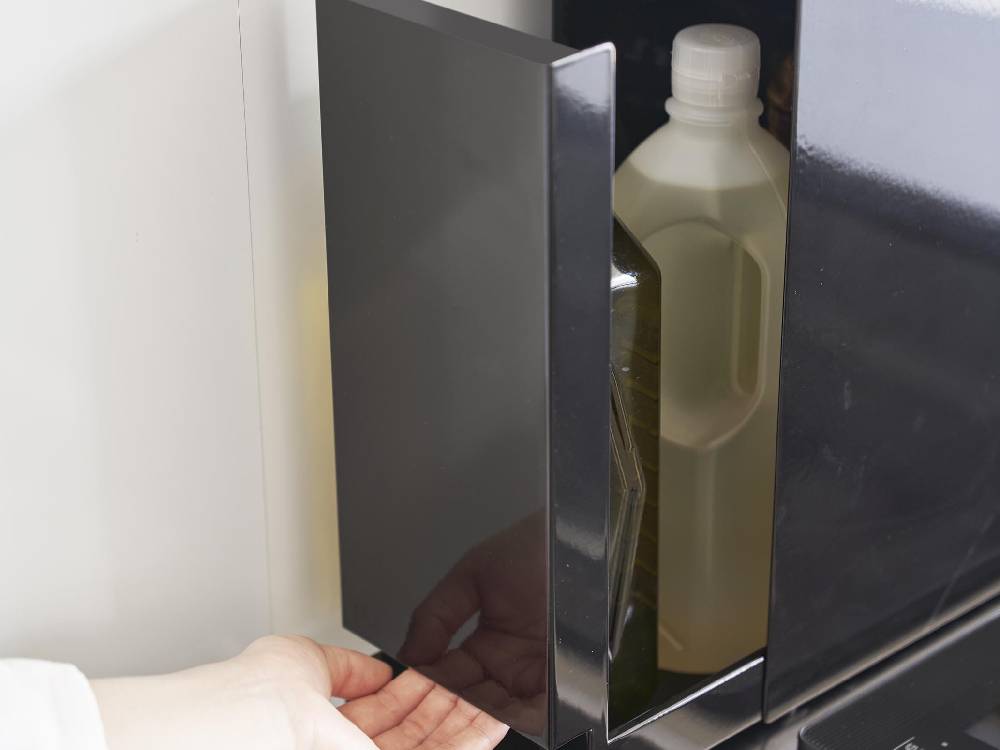 銀色のスチール製タワー型2段調味料ラックがキッチンに設置され、ガラス製の調味料ボトルが並べられている