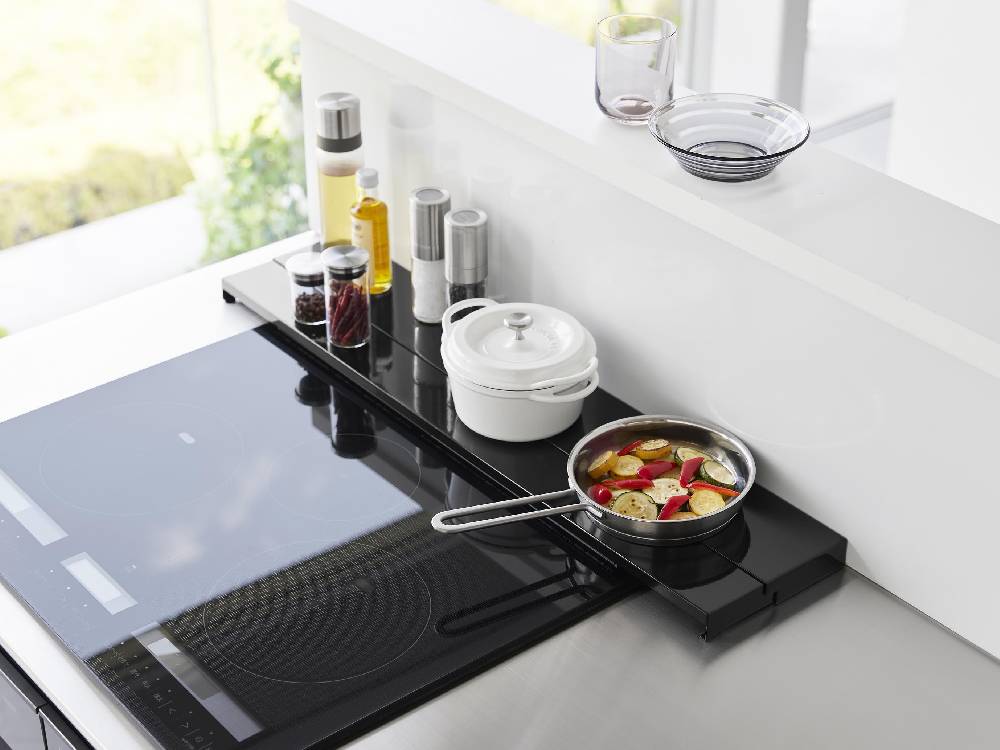 タワー製の奥行伸縮排気口カバーがキッチンのガスコンロ上に取り付けられている様子