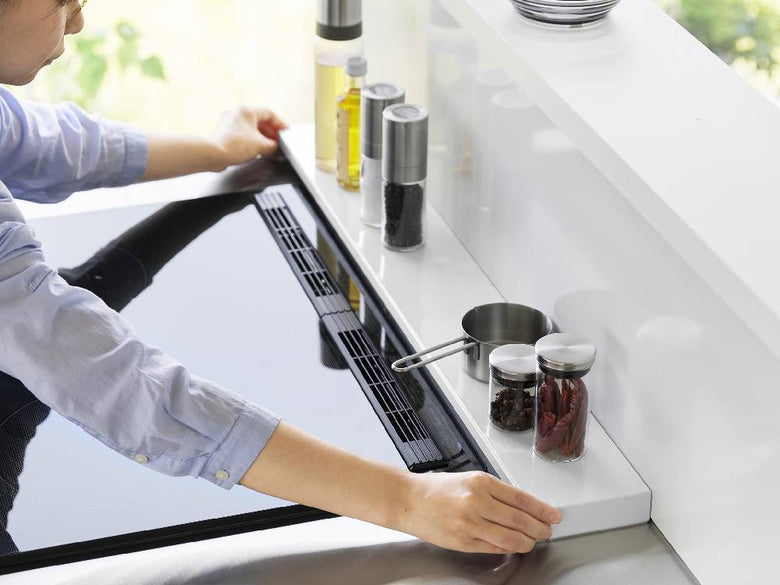 キッチンのコンロ上にスチール製の【tower/タワー】奥行伸縮排気口カバーが取り付けられている様子