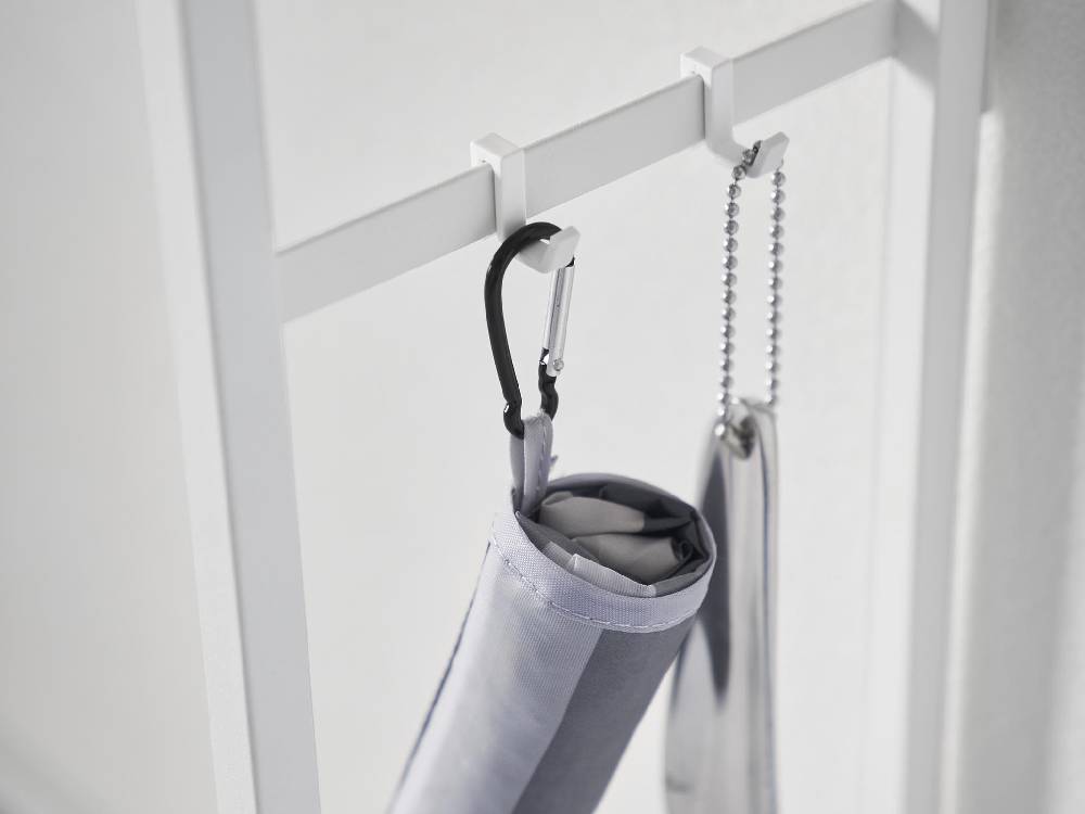 シルバーのロープで吊るされた服掛けと服馬が配置されたソファー裏コンソールテーブル