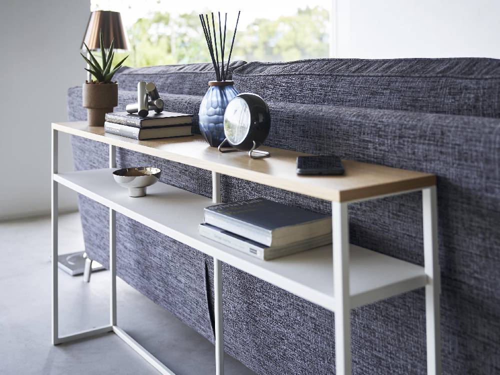 ハードウッドのリビングルームに設置された棚付きソファー裏コンソールテーブル。スチールフレームと天然木天板が特徴的なデザイン。