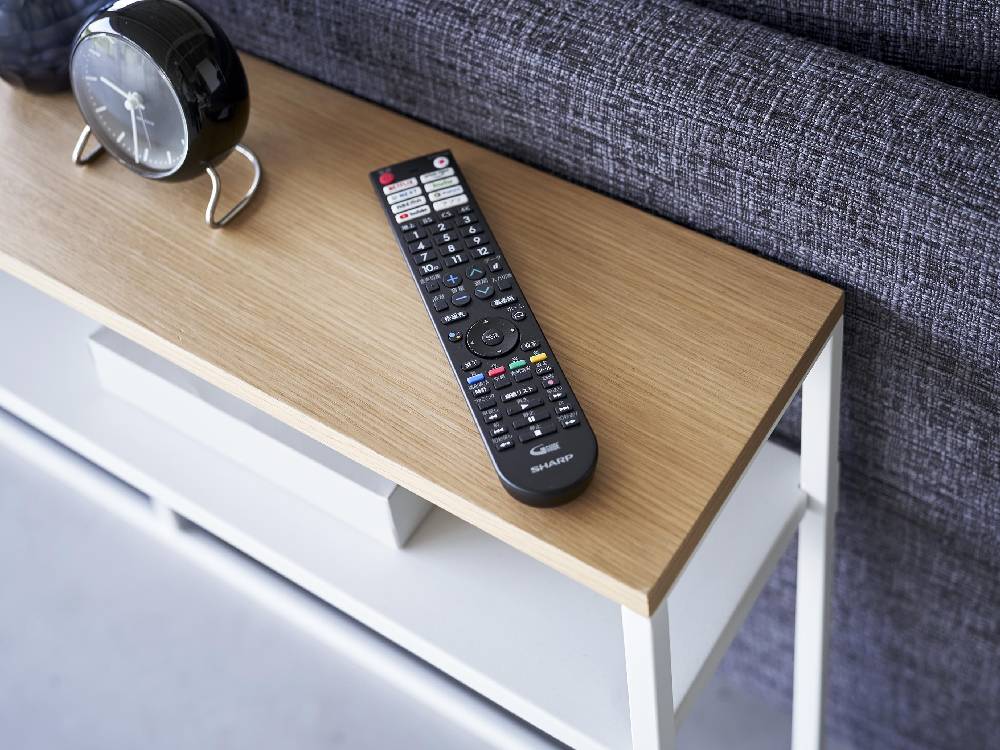 リビングルームに配置された棚付きコンソールテーブル。スチール製の本体と天然木調の天板を使用し、幅126cm、高さ65cmでソファーの裏側に最適なデザイン。