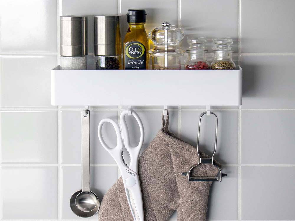 ホワイトのフィルムフックが取り付けられたキッチン棚に瓶や調理器具が整然と配置されている様子