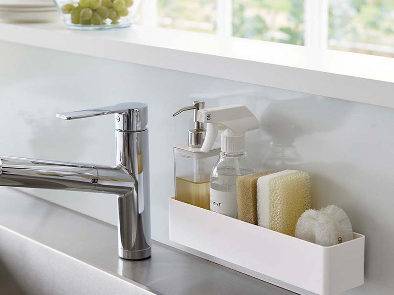 ホワイトのフィルムフックラックが浴室の洗面台に取り付けられ、ソープディスペンサーや蛇口などの設備と共に配置されている様子