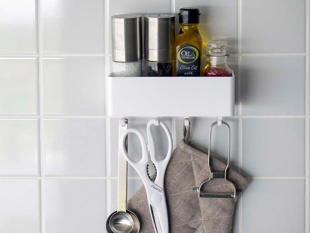 PLATE/プレート フィルムフック ラック W18 ホワイトがキッチンの壁に取り付けられ、ボトルやキッチン用品がシルバーの棚に整然と並べられている様子