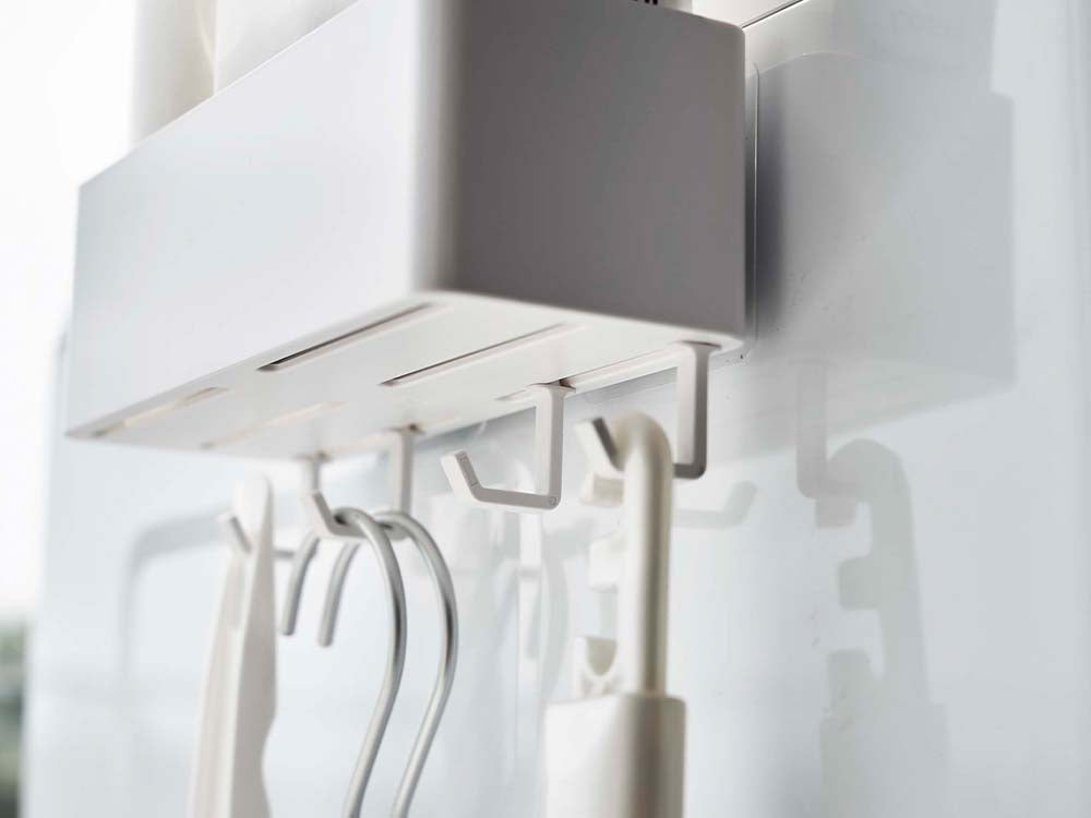 ホワイトのフィルムフックラックW18が壁に設置され、4つのフックに小物が掛けられている様子