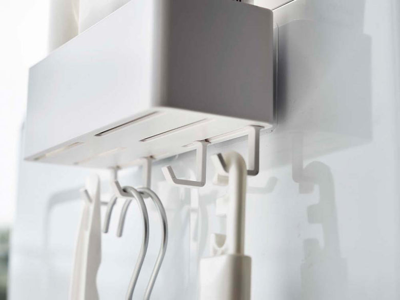 ホワイトのフィルムフックラックW18が壁に設置され、4つのフックに小物が掛けられている様子