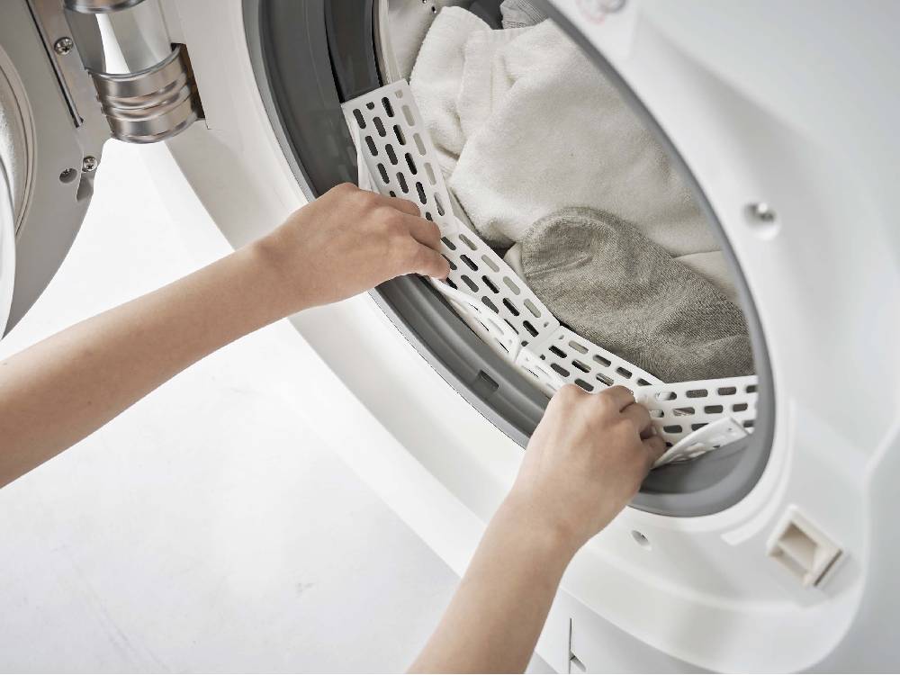 シルバーのドラム式洗濯機に取り付けられたシリコーン製ドアパッキン防止カバー