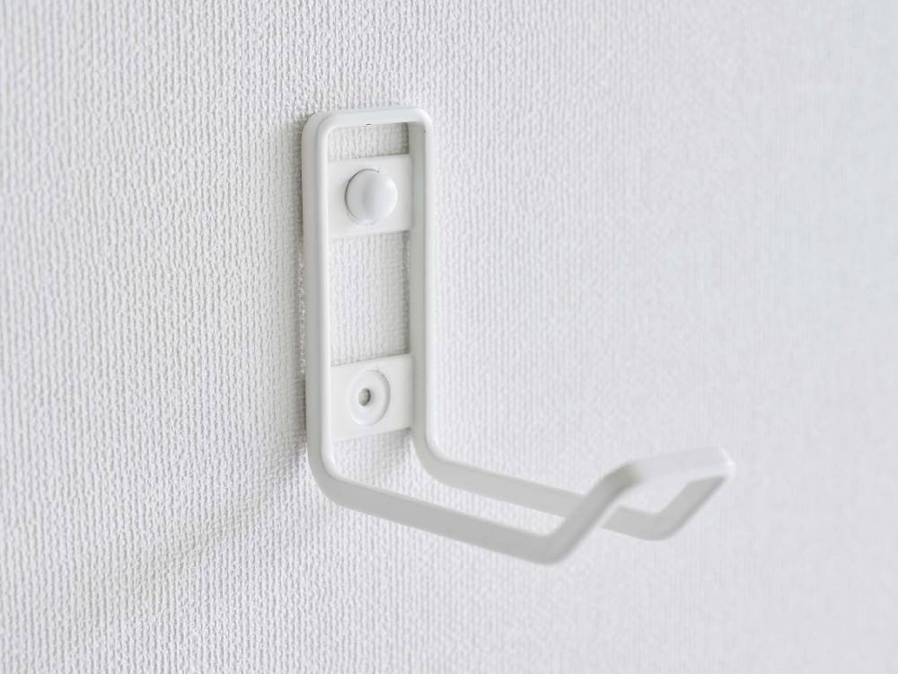 タワー製ウォールトイレ用品収納フックがスチールとプラスチック素材で壁に取り付けられている様子