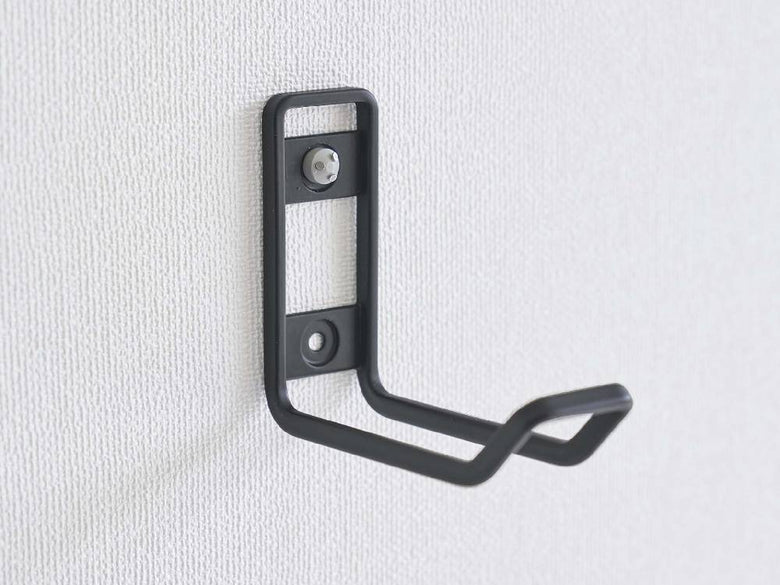 銀色のタワー型ウォールトイレ用品収納フックが壁に取り付けられている様子