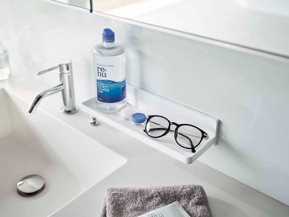 ホワイトのフィルムフックトレーが浴室のシンクキャビネットに取り付けられている様子