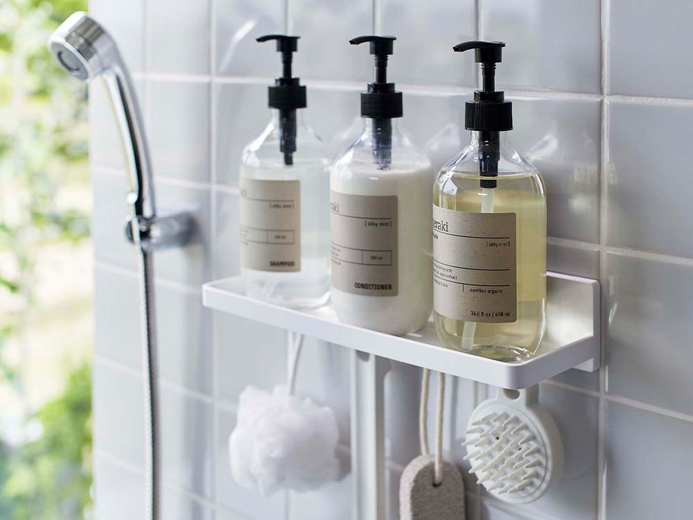 ホワイトのフィルムフック トレーがシンク周りに設置され、石鹸ディスペンサーやタオルが整然と配置されたモダンなバスルーム