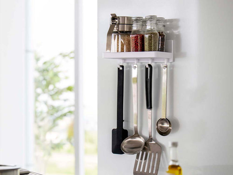 キッチンの棚に置かれた白色のフィルムフック付きプレートトレー。周囲に調理器具や収納用品が整然と配置されています。