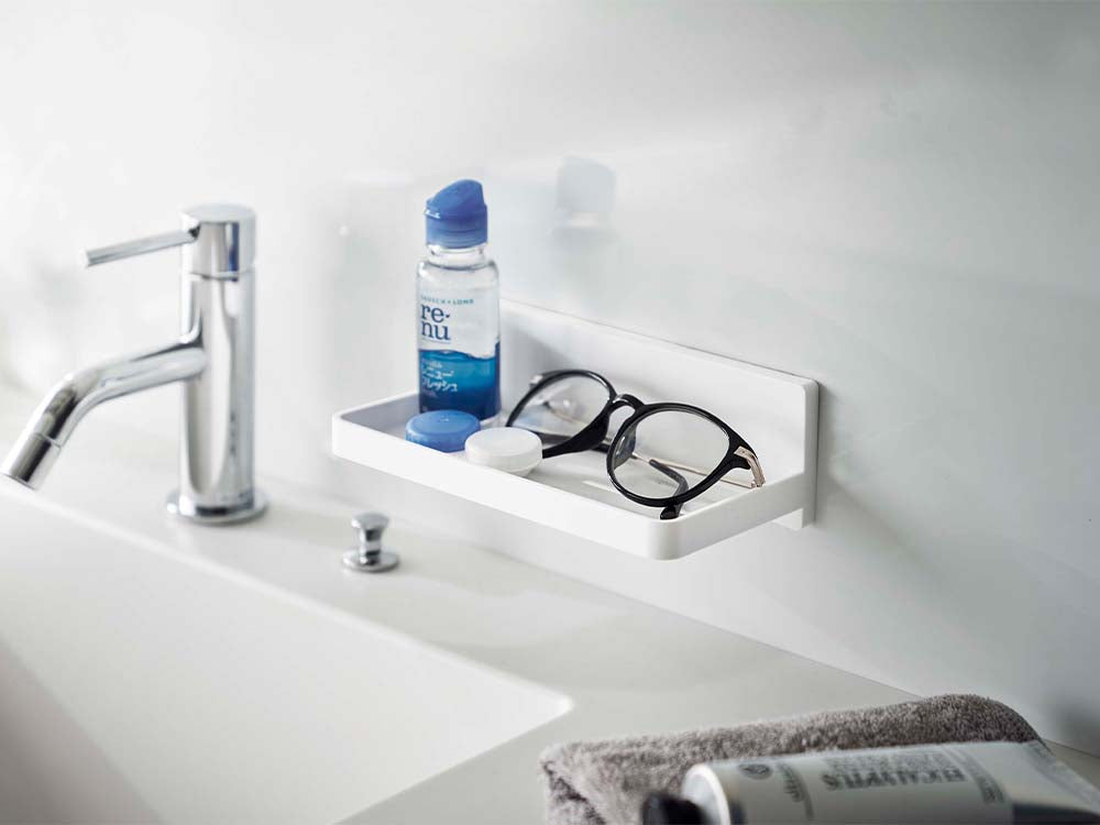 白色のフィルムフックトレーが浴室のシンク周辺に設置され、蛇口やソープディスペンサーが配置されている様子