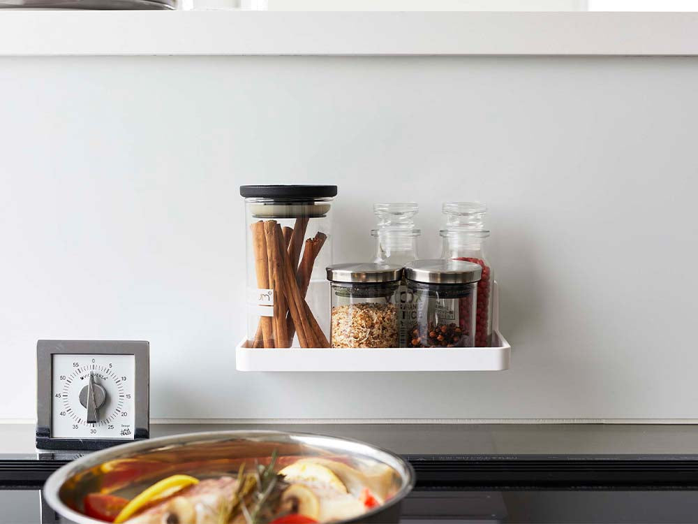 ホワイトのフィルムフック トレー W18がキッチンのカウンター上に設置され、食器や調理器具が整理されている様子