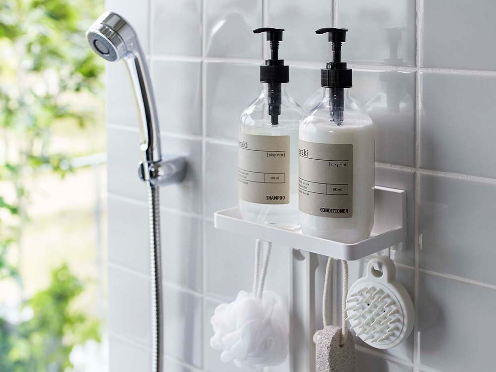 白色のPLATEプレートフィルムフックトレーが浴室の壁に設置され、ソープディスペンサーやボトルがフックに掛けられている様子
