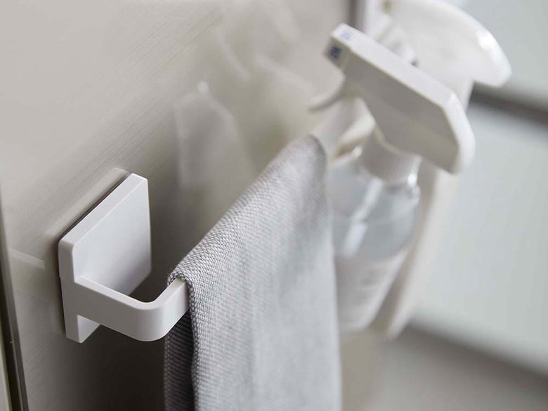 光沢のある壁面に白色のフィルムフック タオルハンガーが取り付けられ、ペーパータオルロールが掛かっている様子