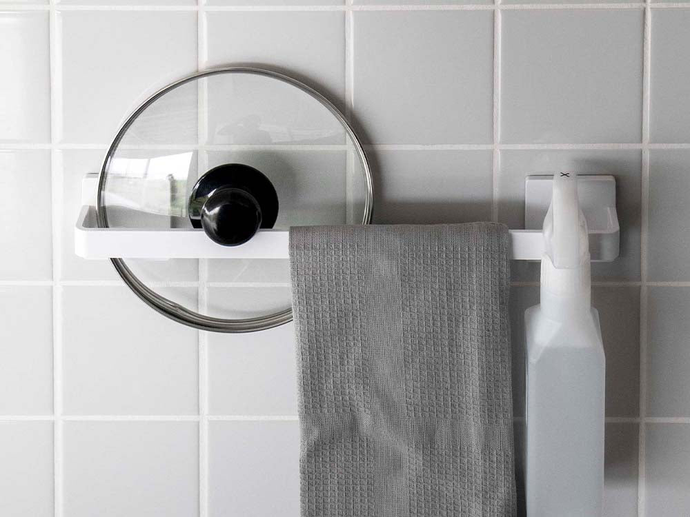 白色のフィルムフックタオルハンガーがバスルームの壁に取り付けられ、ペーパータオルがセットされている様子