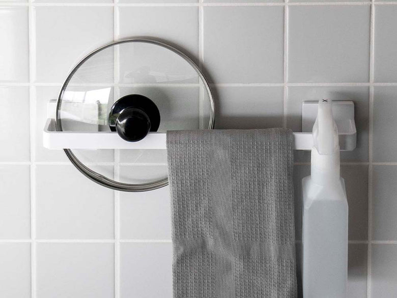 白色のフィルムフックタオルハンガーがバスルームの壁に取り付けられ、ペーパータオルがセットされている様子