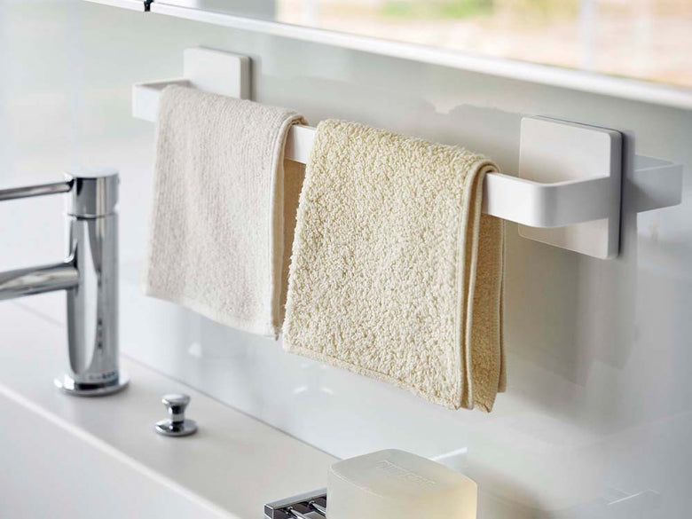 白色のフィルムフックタオルハンガーがバスルームの洗面台に取り付けられている様子