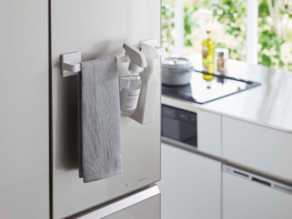 ホワイトのフィルムフックタオルハンガーがキッチンのカウンター上に設置されており、隣にシンクやキャビネットが配置されているインテリアの様子