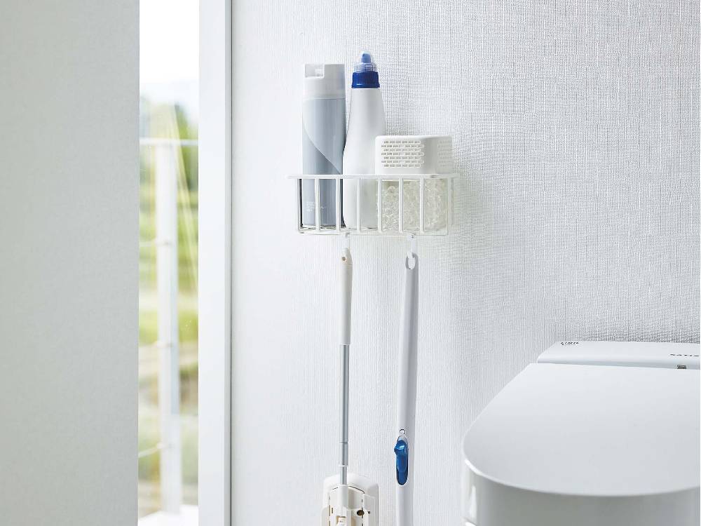【タワー】ウォールトイレ用品収納ラックが浴室の壁に設置され、歯ブラシやペーパータオル、タオルなどの家庭用品を整然と収納している様子