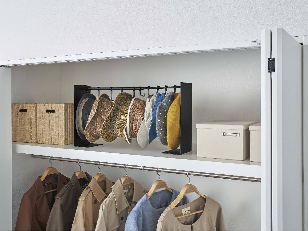 スチール製タワー型帽子収納スタンドがクローゼット内の棚に設置されている様子