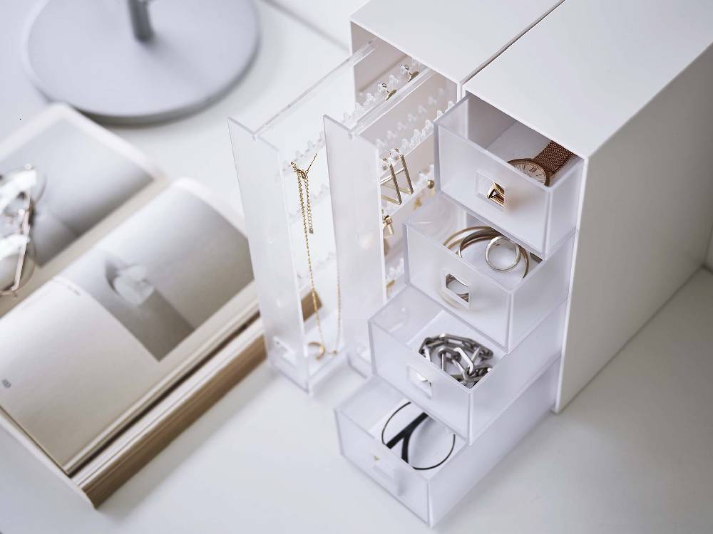 シルバー色のタワー型ボックスディスプレイケースにネックレスとピアスが整然と収納されている様子