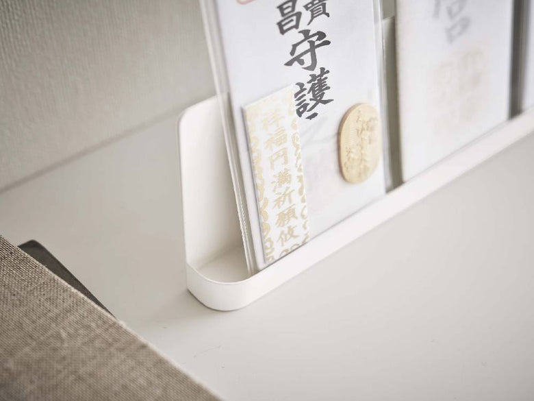 棚に置かれたスマート神札スタンドとオフィス用品、観葉植物が並んでいる様子