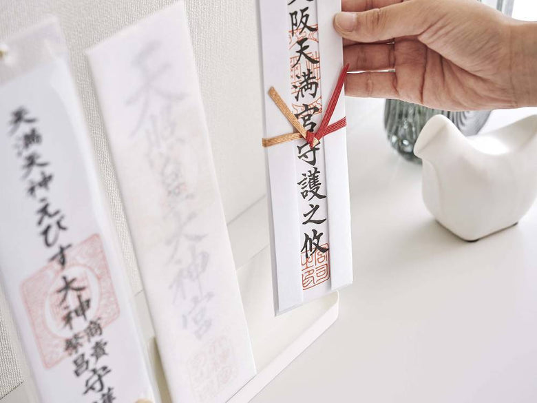 スチール製のスマート神札スタンドに手書きの神札が飾られている写真