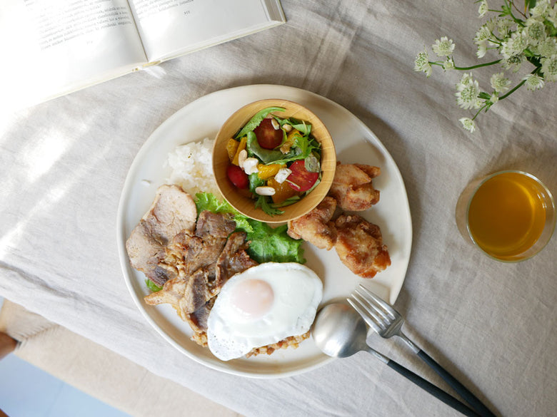 天然木の食洗機対応マルチボールとプレートに盛られた朝食の食卓セット。野菜や肉が並び、木製の食器が整然と配置されています。