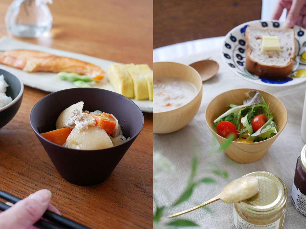 天然木製のマルチボールと食器がテーブルに並び、野菜や調理器具が配置されたキッチンの風景