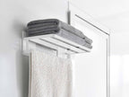 銀色のマグネット式バスタオル棚が浴室の壁に設置され、タオルが掛けられている様子を示す画像