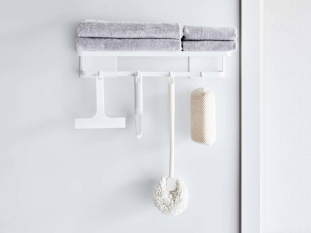マグネット式タワー型バスタオル棚にタオルや衣類ハンガーが掛けられている浴室の様子
