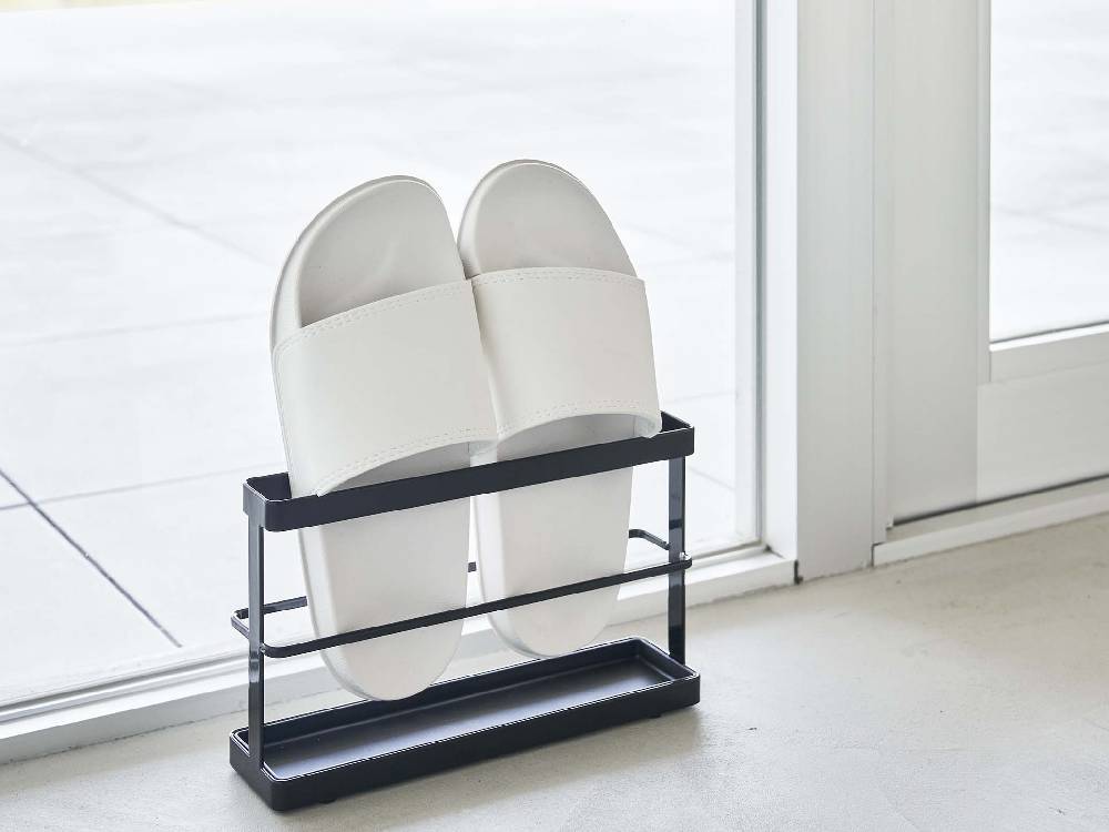 銀色のツーウェイベランダスリッパラック トレー付きが壁に取り付けられている様子